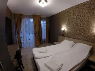 a hotel room with a large bed and a window at VIP Apartments Dobrevi in Primorsko