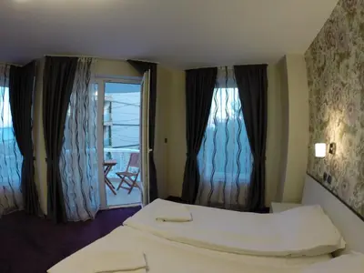 a hotel room with a bed and a balcony at VIP Apartments Dobrevi in Primorsko