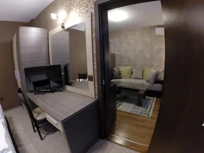 a room with a desk with a mirror and a couch at VIP Apartments Dobrevi in Primorsko