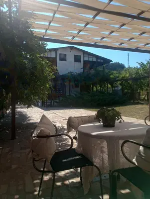 a patio with a table and chairs under a tent at Lozyata Guest House in Obzor