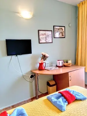 a room with a desk and a tv on a wall at Guest House Maria in Nesebar
