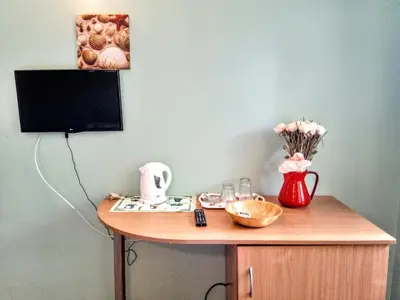 a desk with a vase of flowers and a television at Guest House Maria in Nesebar