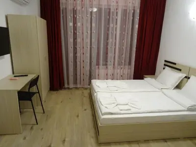 a small room with a bed and a desk at The Sea Lions Guest House in Tsarevo