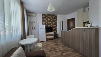 a small kitchen with a table and a refrigerator at Estreya in Tsarevo