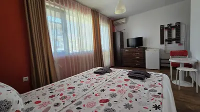 a bedroom with a bed with a flowered blanket at Estreya in Tsarevo