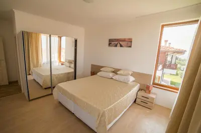 a bedroom with a bed and a large mirror at Villas in Complex Trakiyskiy Bryag in Lozenets