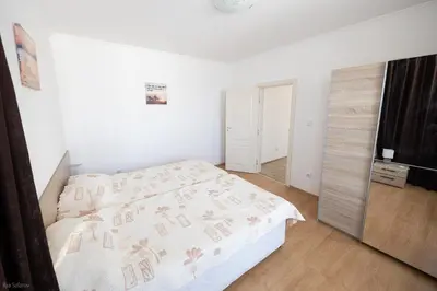 a white bedroom with a bed and a television at Villas in Complex Trakiyskiy Bryag in Lozenets