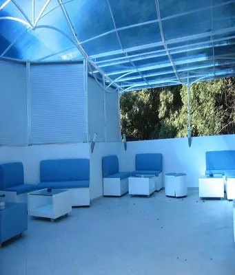 a room with blue chairs and tables under a blue tent at Lurd Family Hotel in Lozenets