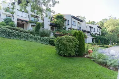 a yard in front of a building with plants at Oasis Resort & Spa Cozy Apartments in Lozenets