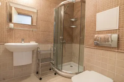 a bathroom with a shower and a sink and a toilet at Oasis Resort & Spa Cozy Apartments in Lozenets