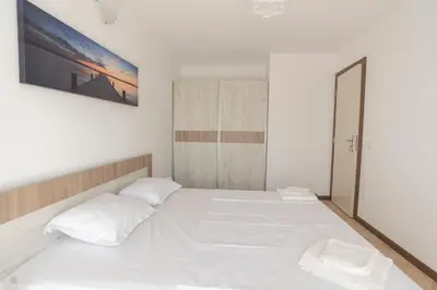 a white bedroom with a large white bed at Oasis Resort & Spa Cozy Apartments in Lozenets