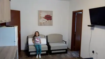 a woman standing in a room with a couch and a chair at Villa Maria in Tsarevo