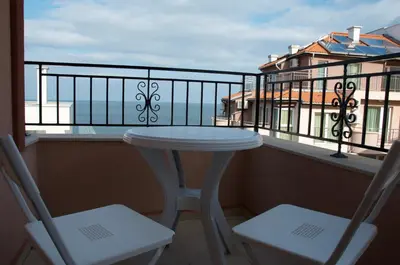 a white table and two chairs on a balcony at Villa Maria in Tsarevo