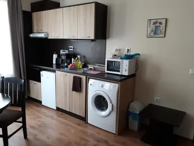 a kitchen with a washing machine and a microwave at Villa Maria in Tsarevo
