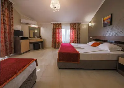 a hotel room with two beds and a television at Guesthouse Phoenix in Obzor