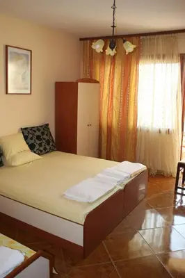 a bedroom with a large bed in front of a window at Homestay Kostadinov in Pomorie