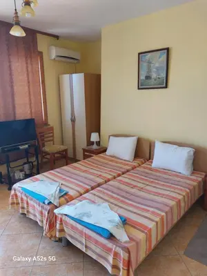 a hotel room with two beds and a piano at Homestay Kostadinov in Pomorie