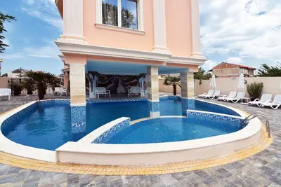 a villa with a swimming pool in a courtyard at Sirena Palace Family Hotel in Obzor