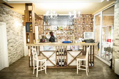 a woman sitting at a bar in a restaurant at семеен хотел Прованс Ахелой in Aheloy