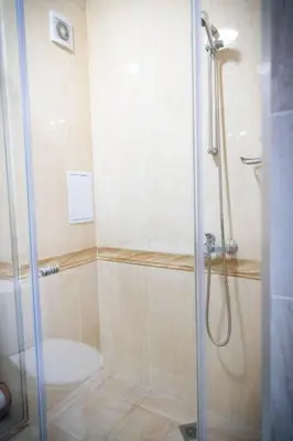 a shower with a glass door in a bathroom at семеен хотел Прованс Ахелой in Aheloy