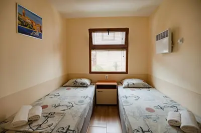 two beds in a small room with a window at Complex Fichoza in Varna City