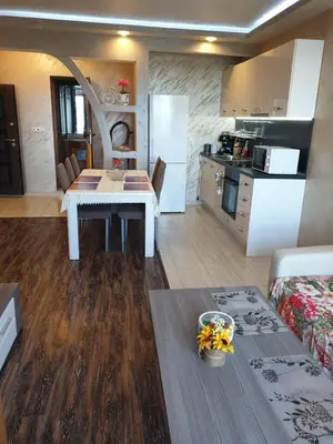 a kitchen and a living room with a table in a room at Sunshine Apartment in Pomorie