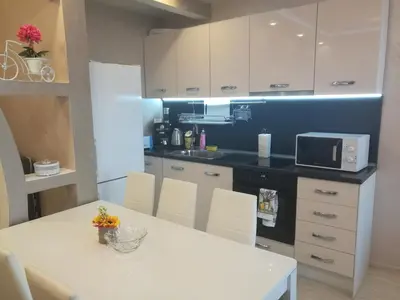 a kitchen with a white table and a microwave at Sunshine Apartment in Pomorie