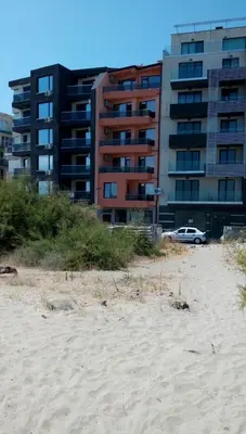 a building next to a beach with a building at Sunshine Apartment in Pomorie