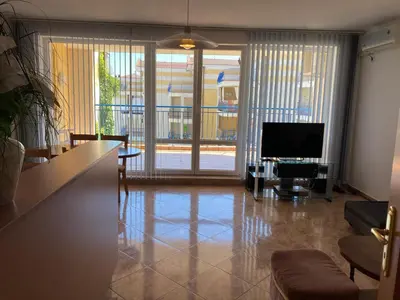a living room with a flat screen tv and a table at Apartments in Complex Panorama in Sozopol