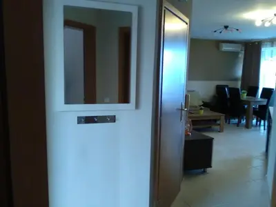 a door leading to a living room with a table at Apartments in Complex Panorama in Sozopol