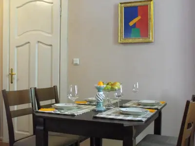 a dining room table with chairs and a table with glasses at Julia Garden in Burgas City