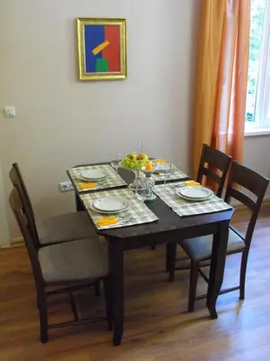 a dining room table with a bowl of fruit on it at Julia Garden in Burgas City