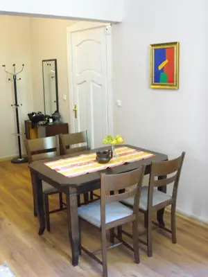 a dining room table and chairs with a table and a painting at Julia Garden in Burgas City