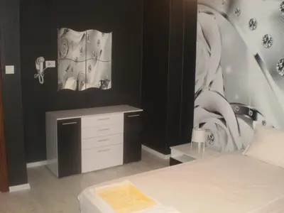 a bedroom with a bed and a desk and a painting at Draga Apartment in Nesebar