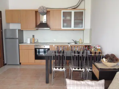 a kitchen with a table and chairs in a kitchen at Apartment on the sea at St Nikolas Complex-Veronika in Chernomorets