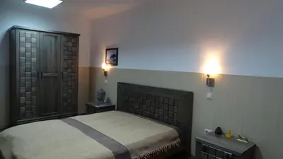 a bedroom with a bed and two tables and a door at Apartment Kafedral in Varna City
