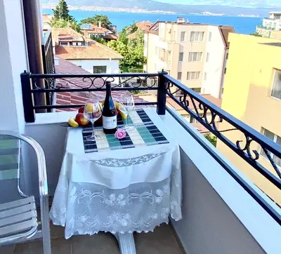 a table with a bottle of wine on a balcony at Guest House Briz in Nesebar