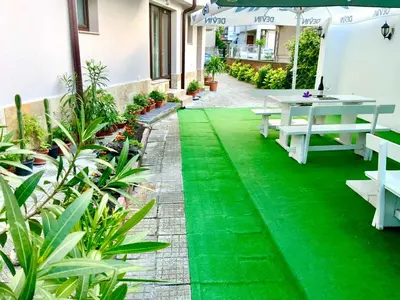 a patio with a table and green grass at Guest House Briz in Nesebar