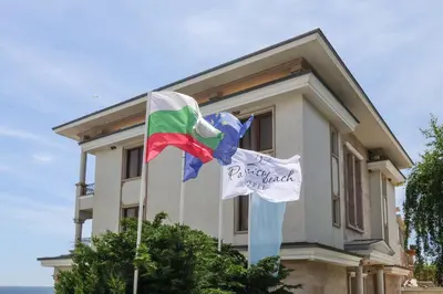 a house with two flags in front of it at Paraiso Theopolis - All Inclusive in Obzor