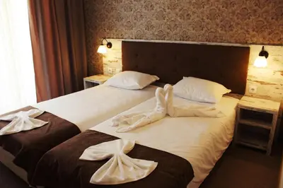 two beds in a hotel room with towels on them at Paraiso Theopolis - All Inclusive in Obzor