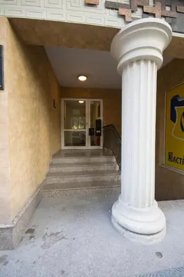 a white column in front of a building with stairs at City Apartments La Casa in Varna City