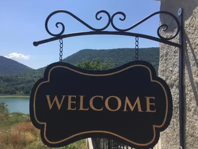 a sign with the word welcome hanging from a building at Eco House Kitana in Tschenge
