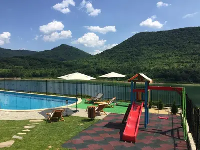 a swimming pool with a slide and a playground at Eco House Kitana in Tschenge