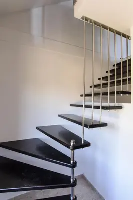 a set of metal stairs with black treads on a white wall at Villa Maja in Varna City