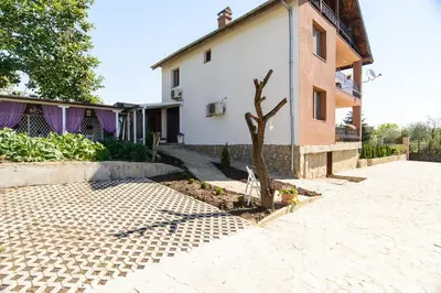 a tree in a courtyard next to a house at Villa Maja in Varna City