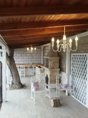 a porch with white chairs and a fireplace at Villa Maja in Varna City