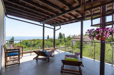 a patio with chairs and a balcony with a view at Galata Residence in Varna City