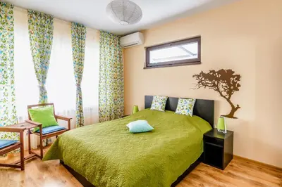 a bedroom with a green bed and a window at Galata Residence in Varna City