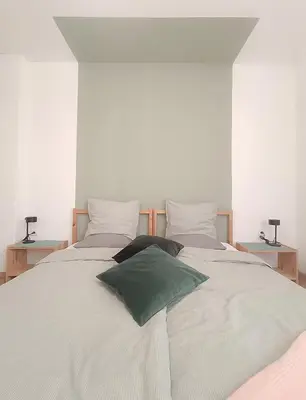 a white bed with two green pillows on it at Apartment Balabanov in Varna City