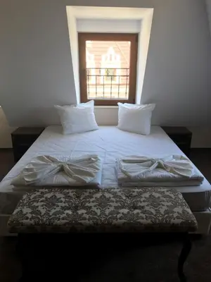 a bed with two pillows on it with a window at Hotel Aristokrat in Obzor